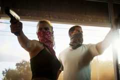 Grand Theft Auto 6 protagonists wearing bandanas with guns pointed while entering a shop