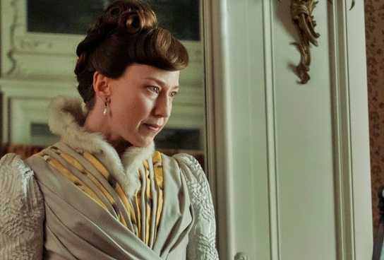 Carrie Coon looking at a portrait in progress in The Gilded Age.